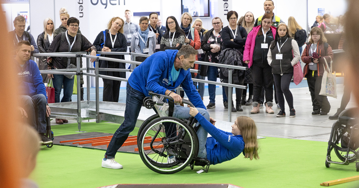 Apuvälineradalla Harri Ahtee opastamassa, miten pyörätuolilla kaatunut henkilö avustetaan ylös.