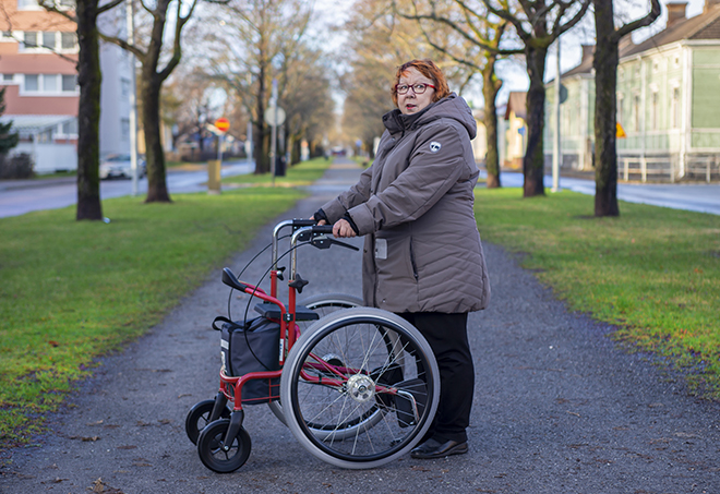 Nainen syksyisellä puistokävelyllä isopyöräisen Wheellatorin kanssa, Tukimet
